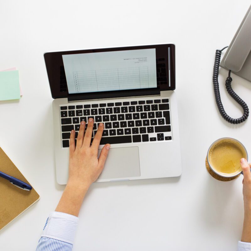 Scrivania per lo studio con un pc, un quaderno, un telefono fisso e dei post it per scrivere gli appunti.