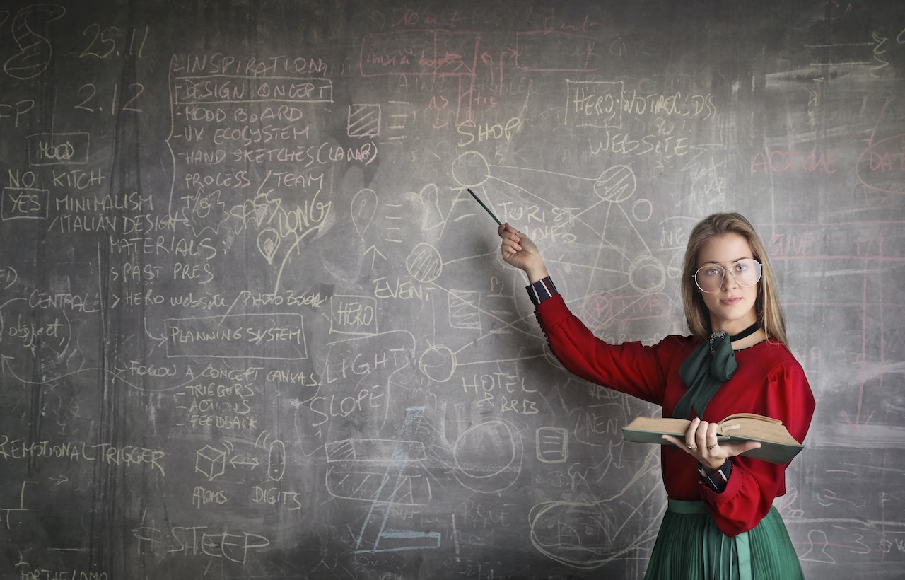 Ragazza che insegna ai suoi compagni utilizzando la tecnica di Feynman per capire a fondo un argomento.
