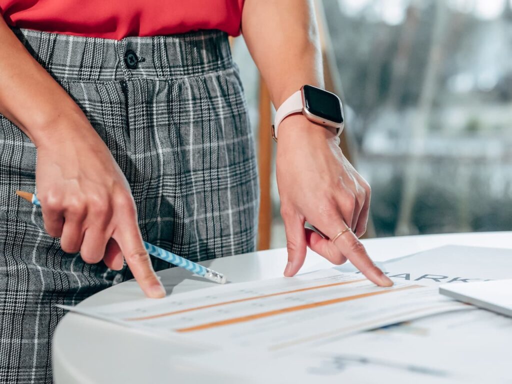 Mani che indicano gli argomenti del formulario di logica test di medicina 2023. Nella mano destra è mantenuta una matita con fantasia azzurra, mentre al polso della sinistra è indossato uno smartwatch.