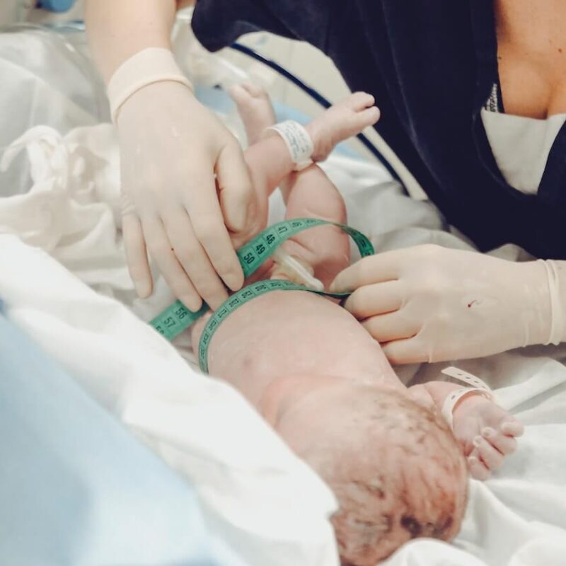 Ostetrica durante le procedure di controllo di salute di un bambino appena nato.
