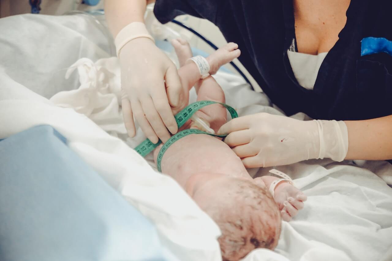 Ostetrica durante le procedure di controllo di salute di un bambino appena nato.