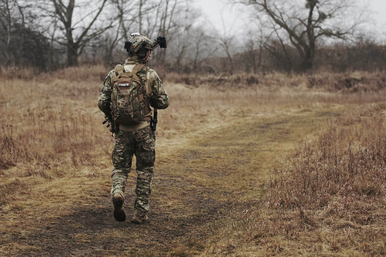 Ufficiale dell'Esercito in uniforme mentre cammina su un sentiero di campagna.