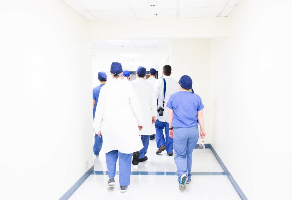Gruppo di medici mentre cammina nel corridoio di un ospedale.