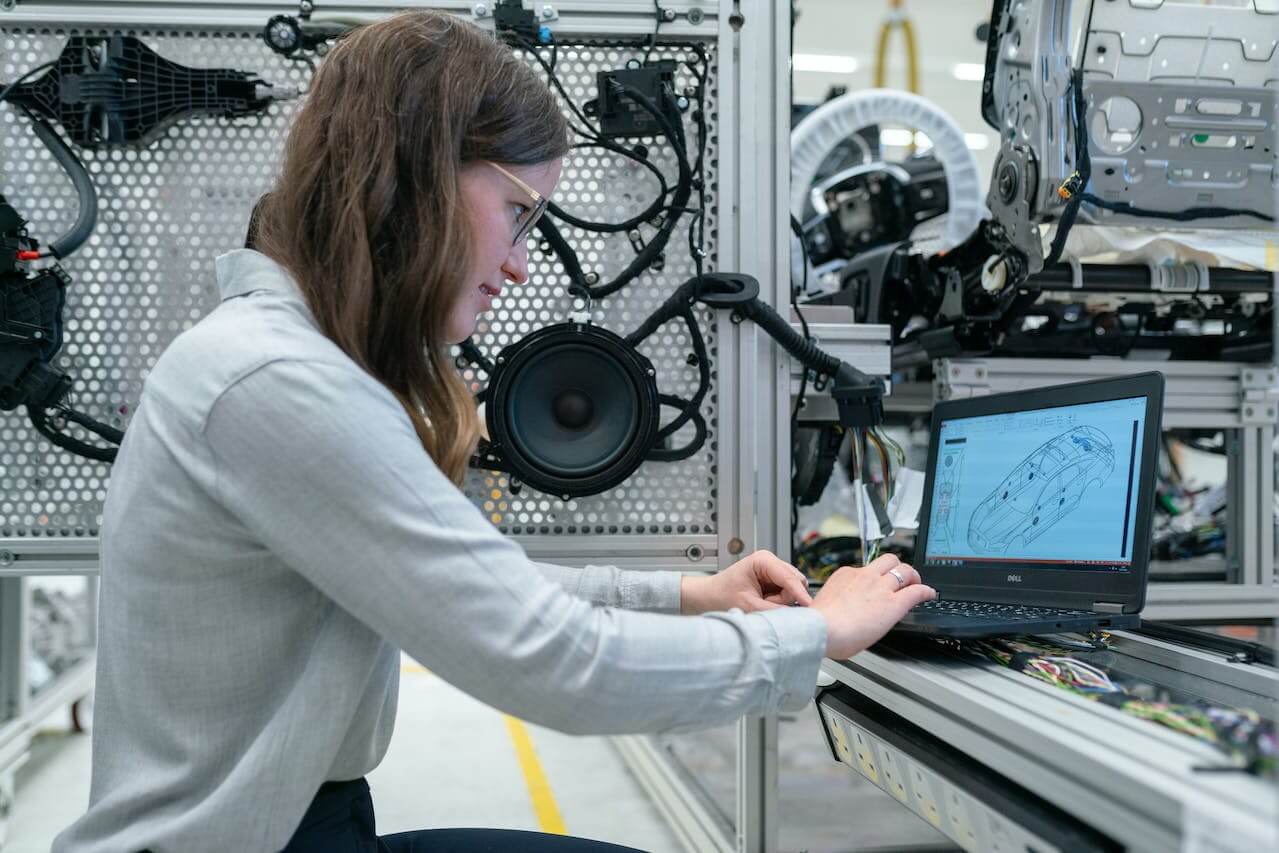 Ingegnere mentre progetta dei componenti per un'automobile sul suo computer.