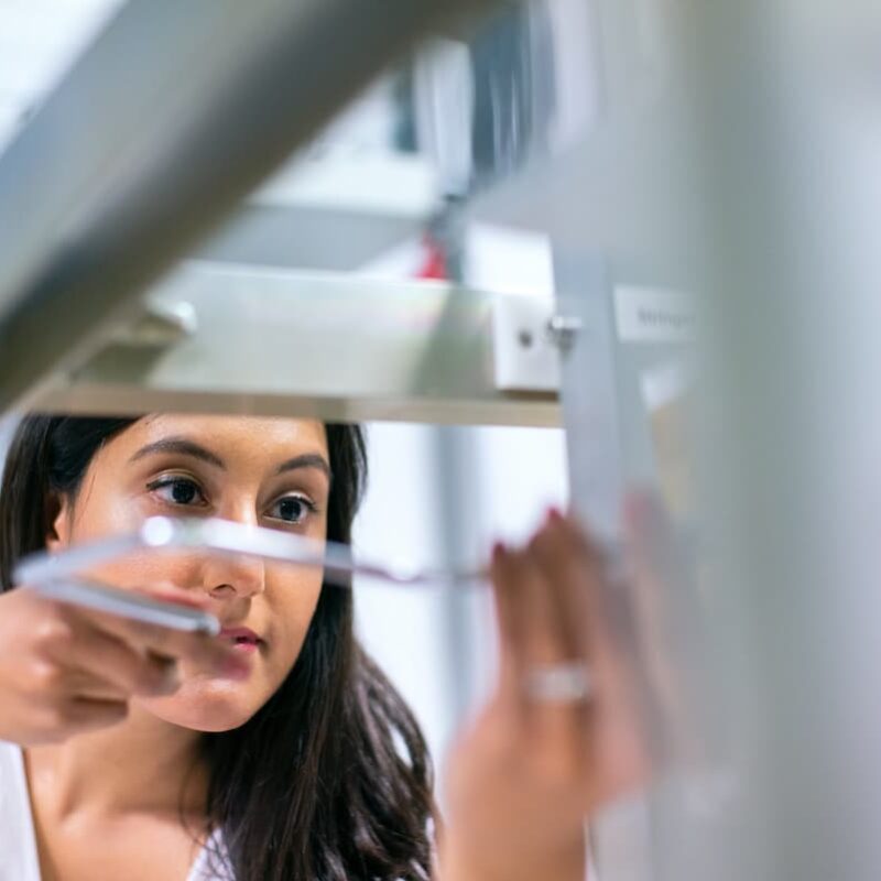 Studentessa di medicina mentre utilizza uno strumento in laboratorio.
