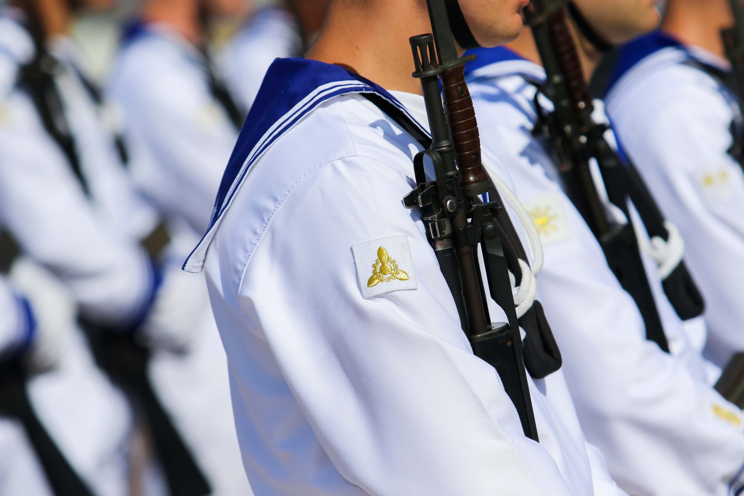 Soldati della Marina Militare in divisa e con fucile imbracciato durante una marcia.
