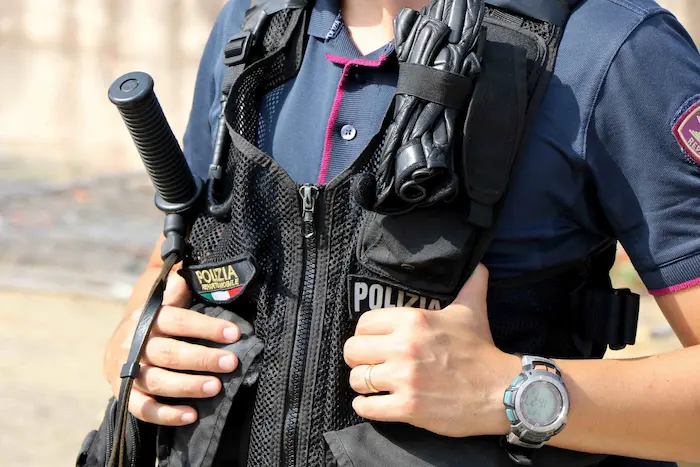 poliziotto che mostra i Gradi della Polizia di Stato sulla sua casacca