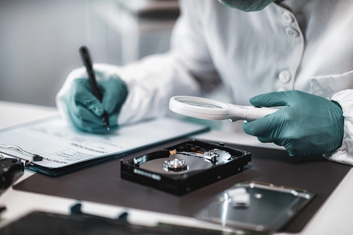 un appartenente dei ris esamina un hard disk alla ricerca di prove