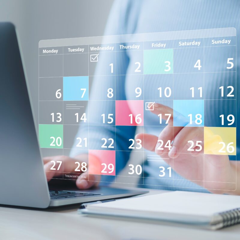 Donna con il portatile mentre usa il calendario per segnare date importanti sulla graduatoria di medicina.