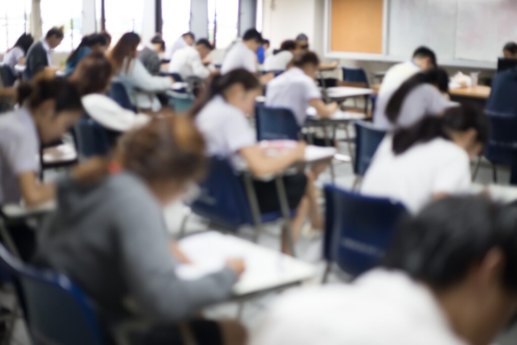 Vista posteriore dell'aula d'esame con studenti all'interno mentre sostengono il test d'ingresso a medicina.