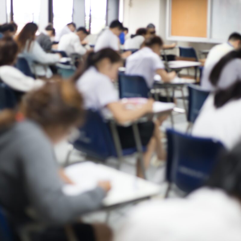 Vista posteriore dell'aula d'esame con studenti all'interno mentre sostengono il test d'ingresso a medicina.