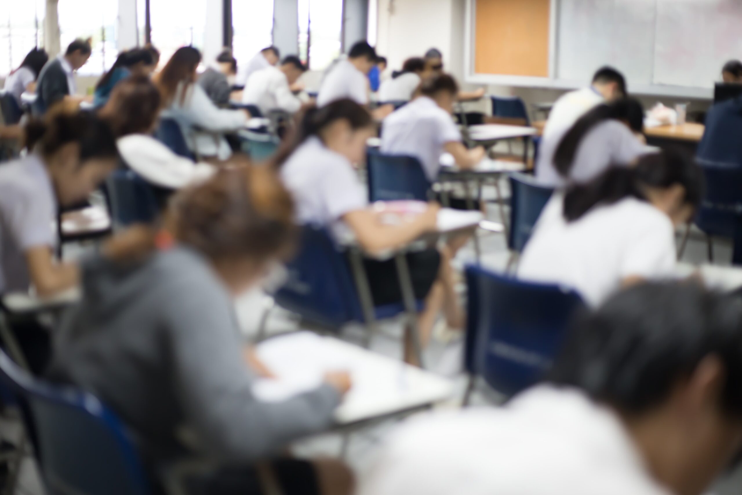 Vista posteriore dell'aula d'esame con studenti all'interno mentre sostengono il test d'ingresso a medicina.