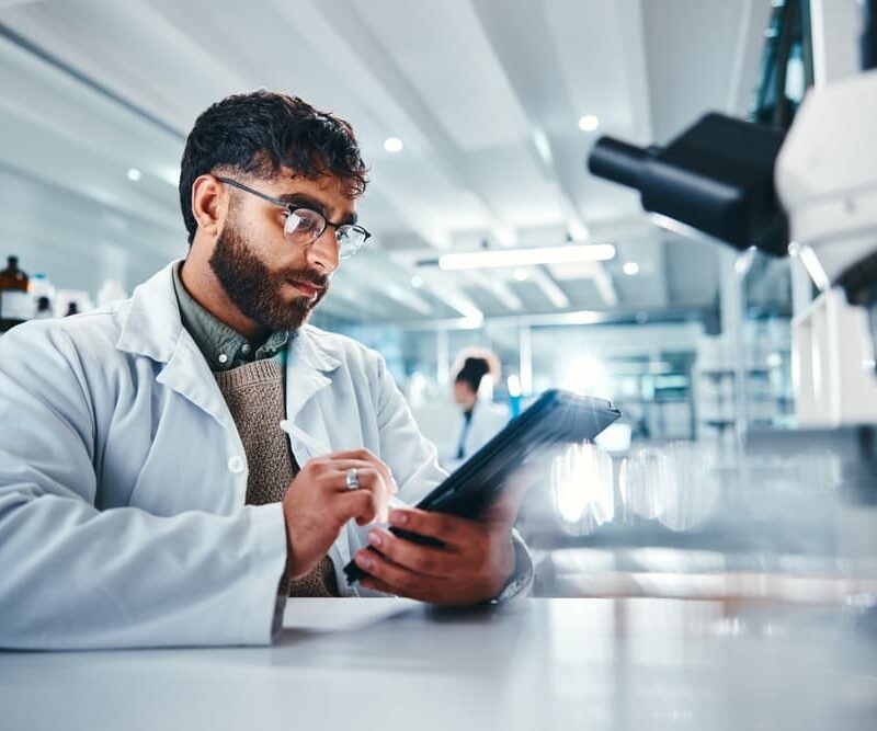 Ricercatore in laboratorio che utilizza un tablet, simbolo dell’innovazione introdotta dalla riforma medicina 2025.