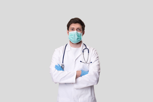 Un medico con le braccia conserte e la mascherina mentre pensa alla Riforma Medicina 2025