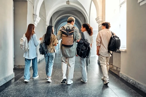 gruppo di studenti camminano in un corridoio parlando di come Cambiare Facoltà