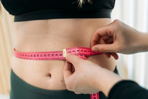 nutrizionista misura il giro vita di una paziente