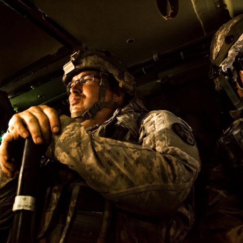 Soldati in uniforme in movimento su un mezzo di trasposrto.