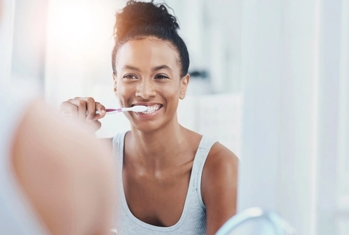 donna si lava i denti allo specchio