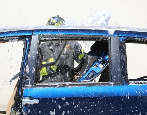 Intervento dei Vigili del Fuoco mentre rompono il finestrino di un veicolo durante un'operazione di soccorso, scena che rappresenta le competenze pratiche richieste per chi vuole sapere come diventare Vigile del Fuoco