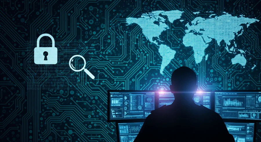 agente della polizia postale seduto ad una scrivania lavora al computer