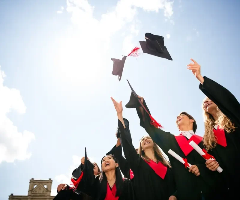 gruppo di laureati lancia il cappello in aria per festeggiare di essersi laureati in una delle università più richieste in italia