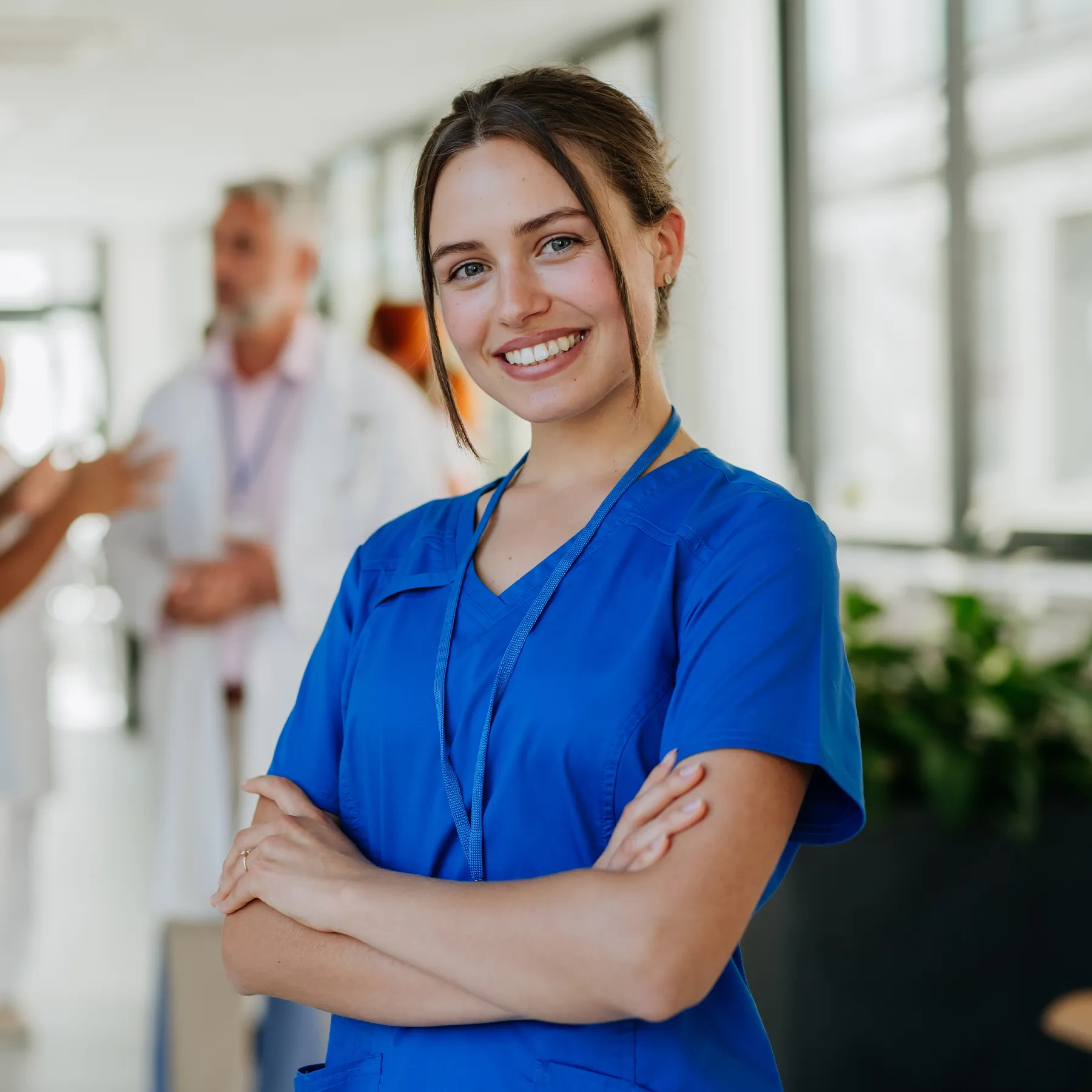 Studentessa di Medicina in divisa blu che sorride in corsia, simbolo della preparazione al semestre filtro con Futura.